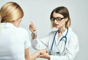 vrouw dokter geven een injectie naar een bang vrouw geduldig in een wit t-shirt foto