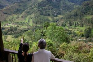 senior moeder en volwassen dochter op reis samen Bij de mooi visie punt over- de kokos vallei Bij Salento, gelegen Aan de regio van quindio in Colombia foto