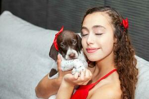 mooi jong meisje gekleed in rood met haar klein Frans braque puppy foto