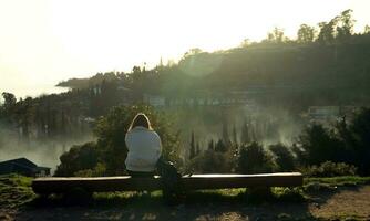 nieuw athos. abchazië.mars, 26, 2023. een meisje is zittend Aan een park bank en aan het kijken de zonsondergang. foto