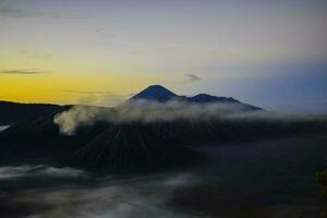 mooi kleurrijk zonsopkomst over- monteren bromo en wild eiland in monteren bromo nationaal park foto