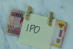 ipo schrijven Aan kleverig aantekeningen en Indonesisch valuta geïsoleerd Aan houten tafel. foto