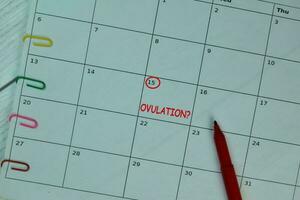 ovulatie Aan maandelijks kalender en gemarkeerd 15e geïsoleerd Aan de tafel foto