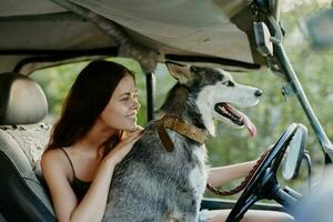 vrouw en haar schor hond gelukkig op reis in auto glimlach met tanden herfst wandelen met huisdier, reizen met hond vriend foto