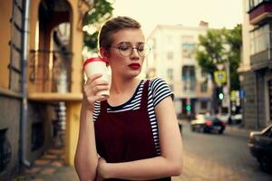 mooi vrouw met bril buitenshuis een kop van koffie wandelen foto