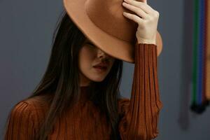jong vrouw bruin hoed hand- gebaren bruin trui mode emoties levensstijl foto