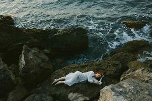 mooi vrouw in wit bruiloft jurk Aan zee kust nat haar- ongewijzigd foto