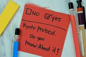 concept van Kyoto protocol, Doen u weten over het Nee of Ja schrijven Aan kleverig aantekeningen geïsoleerd Aan houten tafel. foto
