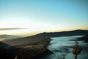 mooi kleurrijk zonsopkomst over- monteren bromo en wild eiland in monteren bromo nationaal park foto