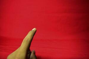 hand- met vinger gehouden omhoog Aan de rood achtergrond foto