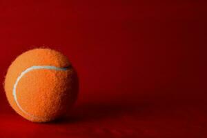 oranje tennis bal Aan een rood achtergrond foto