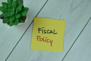 concept van fiscale het beleid schrijven Aan kleverig aantekeningen geïsoleerd Aan houten tafel. foto