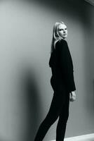een jong elegant meisje in een jasje poses in een zwart en wit studio. een concept voor kleding merken. koel aanbod banier voor uitverkoop foto