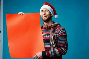 knap Mens in een Kerstmis oranje mockup poster blauw achtergrond foto