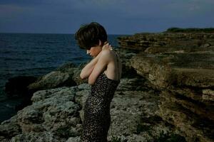 vrouw met bedenken in jurk Aan natuur rotsen landschap buitenshuis ongewijzigd foto