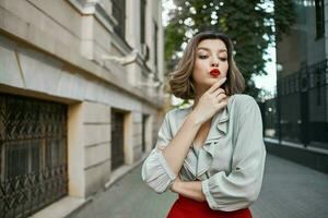 mooi vrouw met rood lippen wandelen naar beneden de straat rust uit foto
