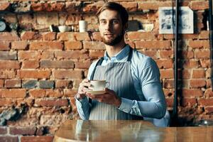 mannetje ober schort koffie kop professioneel barista werk foto