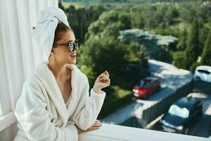 aantrekkelijk jong vrouw in zonnebril Bij de hotel Aan de balkon ontspanning concept foto