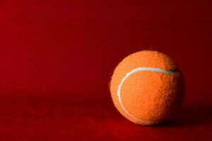 oranje tennis bal Aan een rood achtergrond foto