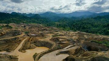 antenne visie van werk van vrachtwagens en de graafmachine in een Open pit Aan goud mijnbouw. centraal sulawesi, Indonesië, maart 3, 2022 foto