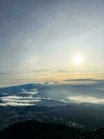 panorama van vloeiende mist golven Aan berg tropisch regenwoud, beeld over- de wolken verbazingwekkend natuur achtergrond met wolken en berg pieken in purbalingga. centraal Java, Indonesië. december 13, 2022 foto