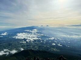 panorama van vloeiende mist golven Aan berg tropisch regenwoud, beeld over- de wolken verbazingwekkend natuur achtergrond met wolken en berg pieken in purbalingga. centraal Java, Indonesië. december 13, 2022 foto