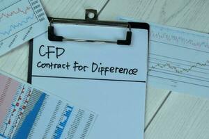concept van cfd - contract voor verschil schrijven Aan papierwerk geïsoleerd Aan houten tafel. foto