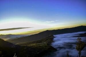 mooi kleurrijk zonsopkomst over- monteren bromo en wild eiland in monteren bromo nationaal park foto