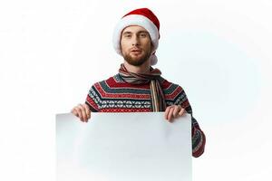 emotioneel Mens in een Kerstmis hoed met wit mockup poster Kerstmis geïsoleerd achtergrond foto