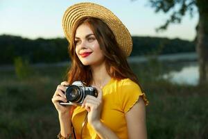 mooi vrouw glimlach rood lippen camera natuur vers lucht geel t-shirt hoed foto