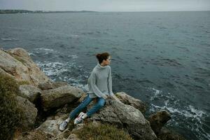 portret van een vrouw strand toerisme bewolkt weer steen kust levensstijl foto