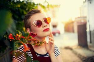 mooi vrouw vervelend zonnebril buitenshuis mode poseren bloemen foto