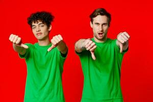 gelukkig vrienden in groen t-shirts tonen duimen naar beneden emoties foto