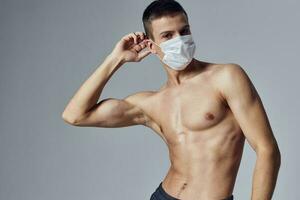 een Mens in een medisch masker met een gemotiveerd omhoog druk op houdt zijn hand- in de buurt zijn hoofd poseren Gezondheid bescherming foto