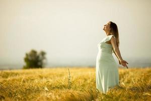 zwangere vrouw in witte jurk in de natuur foto