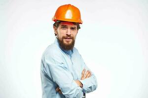 vrolijk Mens oranje moeilijk hoed werk industrie professioneel levensstijl licht achtergrond foto