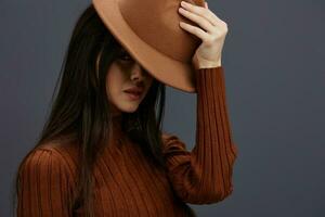 brunette in hoed pret bruin trui poseren gewoontjes slijtage grijs achtergrond foto