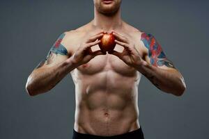 atletisch jong Mens met gespierd spieren en buikspieren naakt torso appel Gezondheid foto