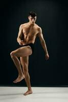 mannetje bodybuilder met een gespierd lichaam in donker slipje poseren foto