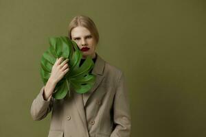 blond vrouw groen palm blad jas helder bedenken geïsoleerd achtergrond foto