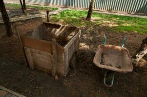 nog steeds leven met een houten compost bak en kruiwagen. composteren. duurzame middelen en levensstijl. eco landbouw foto