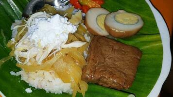 Indonesisch voedsel liwet rijst. een traditioneel Javaans rijst- geserveerd met kip, tofu, tempé, groente, Chili en breed bonen foto