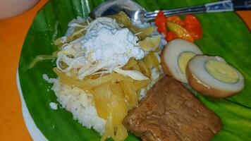 Indonesisch voedsel liwet rijst. een traditioneel Javaans rijst- geserveerd met kip, tofu, tempé, groente, Chili en breed bonen foto