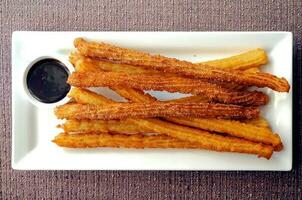 Spaans donut churros vers gemaakt met donker chocola dompelen saus foto