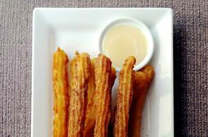 zelfgemaakte Spaanse donut churros met witte chocolade dipsaus foto