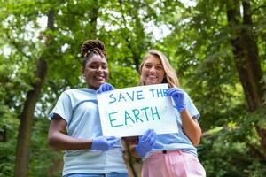 twee vrijwilligers van verschillend races houden een papier en tonen hoe belangrijk het is naar nemen zorg van de omgeving. vrijwilligerswerk concept. foto