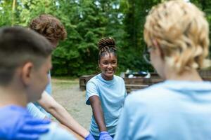 portret van vrijwilligers vouwen hun armen. milieuactivisten zijn in een openbaar park. ze zijn in blauw t-shirts. de concept van vriendschap en helpen foto