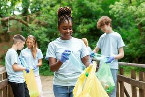 een multi-etnisch groep van mensen, schoonmaak samen in een openbaar park, zijn beschermen de omgeving. de concept van recycling en schoonmaak foto