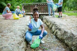 vrouw met de hand plukken bijeenkomst omhoog vuilnis plastic rietjes vuilnis van de rivier- Bij de park. wereld milieu dag.omgeving concept. foto