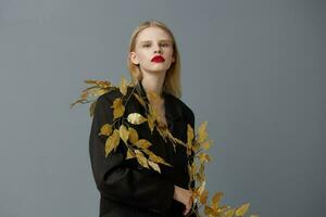 portret van een vrouw mode gouden bladeren in zwart jasje studio model- ongewijzigd foto